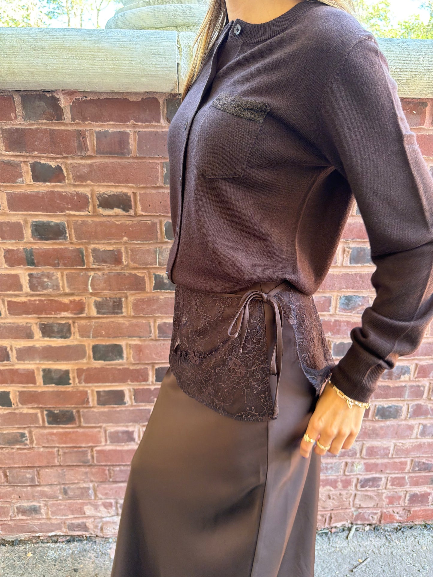 Side view of chocolate brown cardigan with lace trim pocket detail on chest