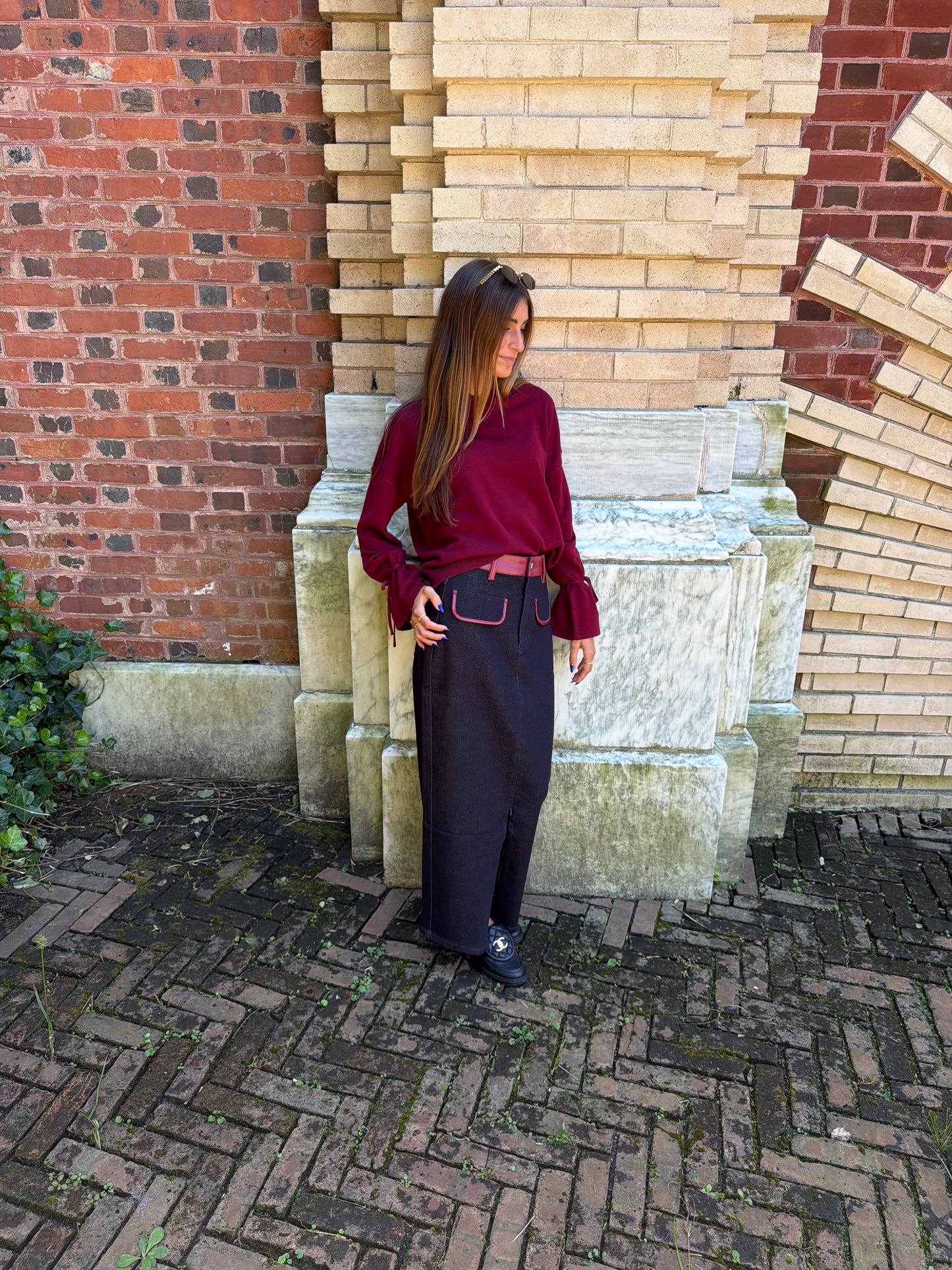 Side view of burgundy v-neck sweater with tie sleeve detail