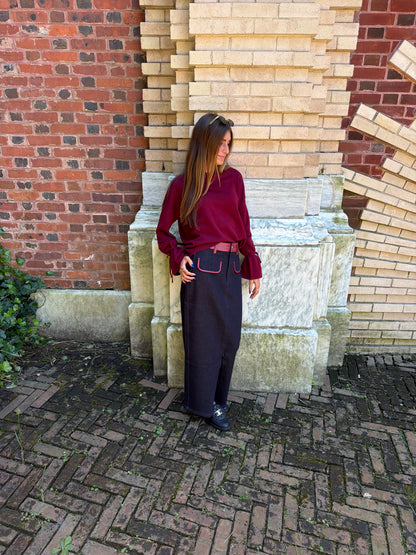 Side view of burgundy v-neck sweater with tie sleeve detail
