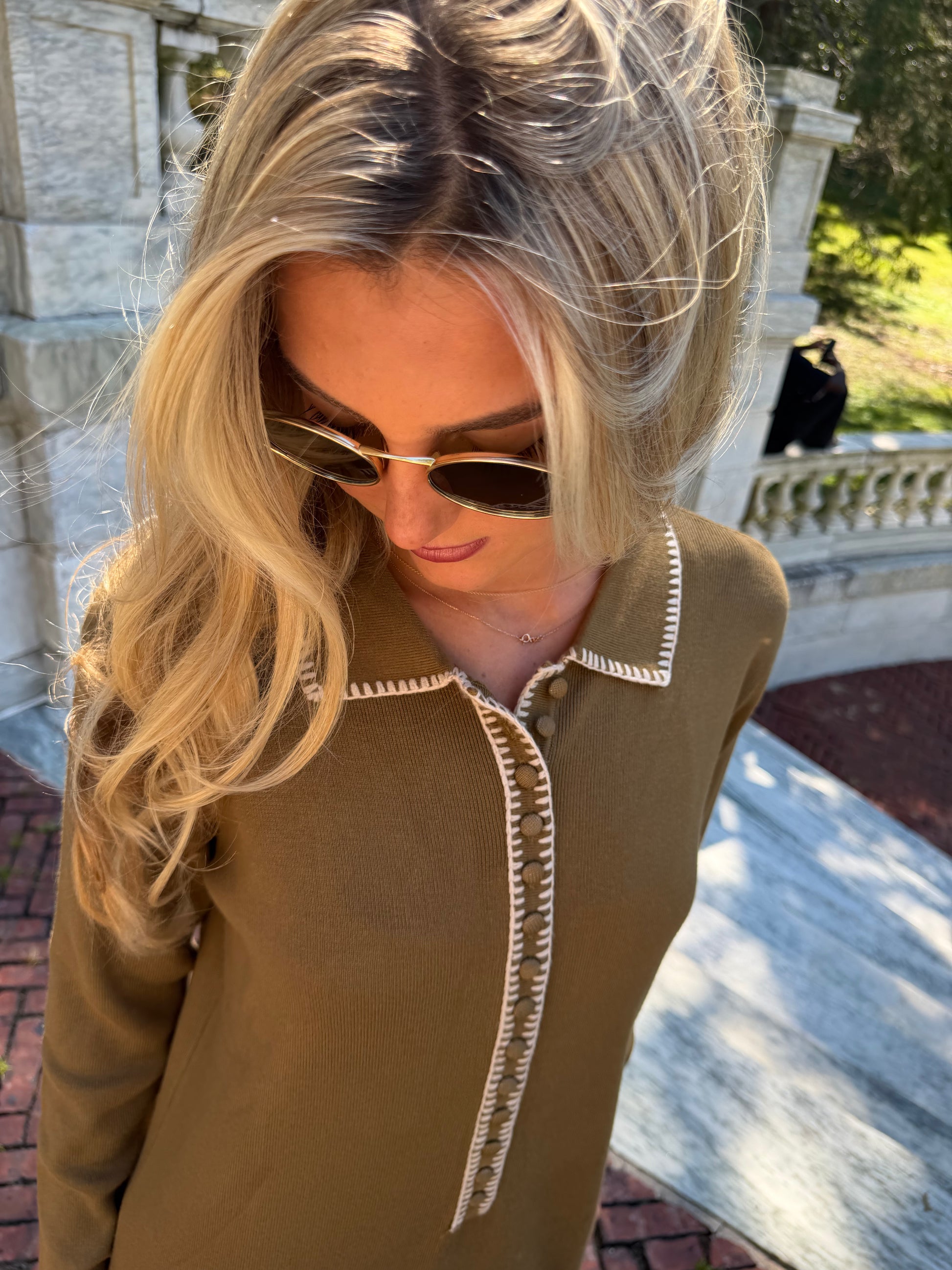 Close up details of olive green polo knit dress with oat contrast stitching and collar placket detail