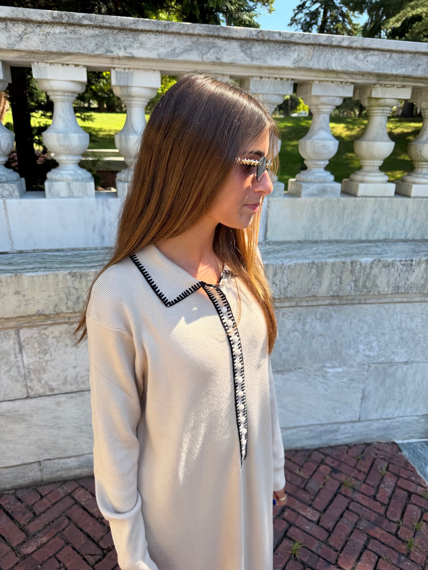 Close up details of oat polo knit dress with black contrast stitching and collar placket detail