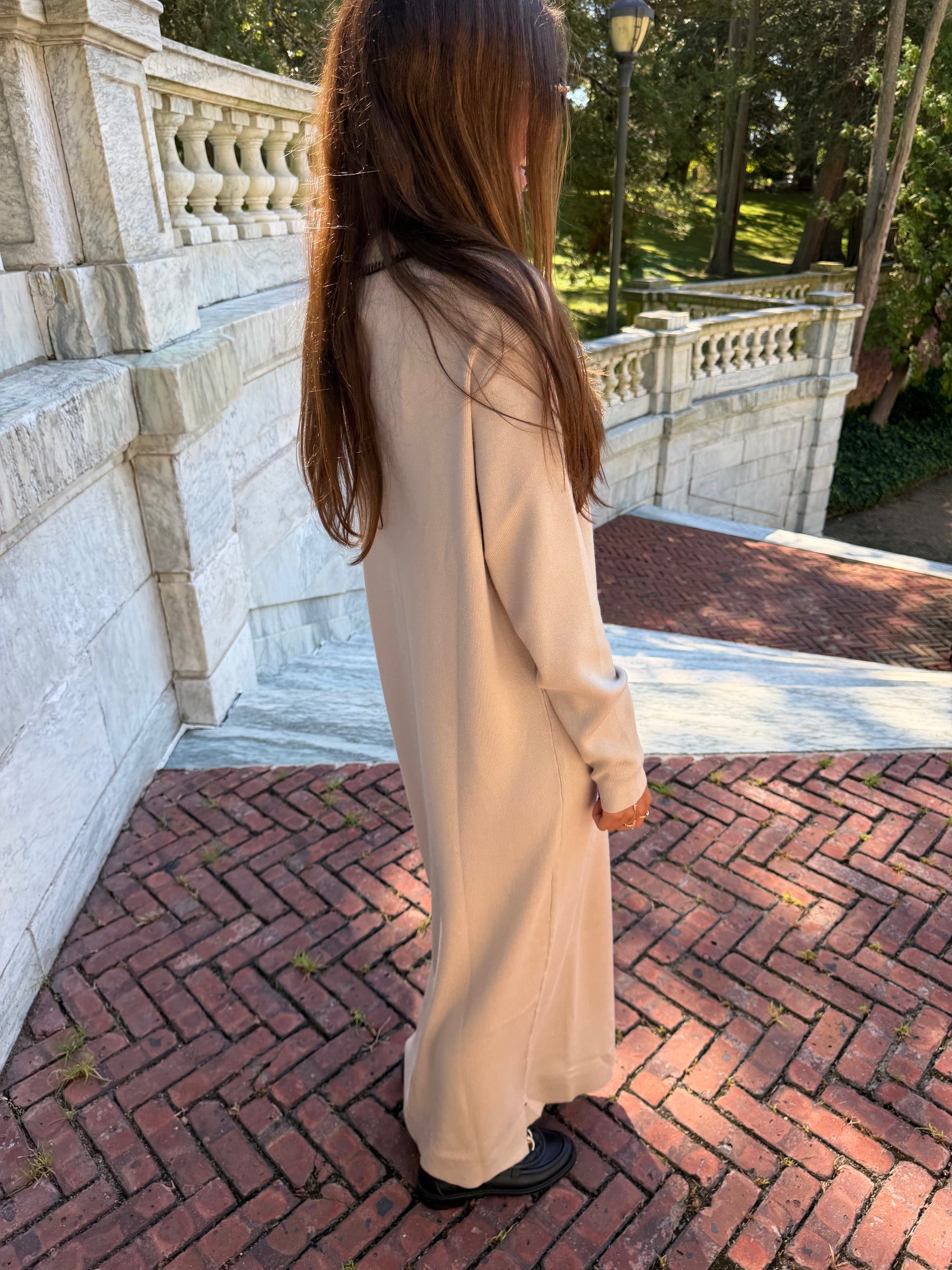 Side view of oat polo knit dress with black contrast stitching and collar placket detail