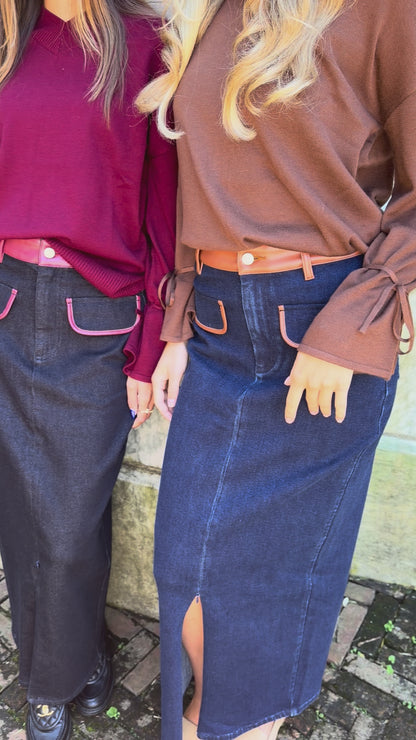 Video of blue denim maxi skirt with chestnut leather trim detail, front flap pockets and zipper closure slit and black denim maxi skirt with burgundy leather trim detail, front flap pockets and zipper closure slit